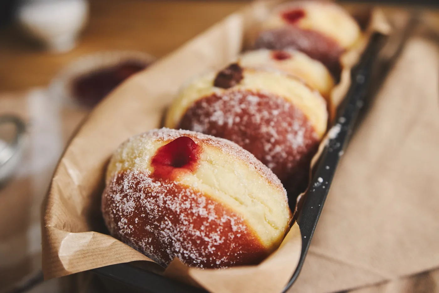 Pączki z nadzieniem w papierze na łopatce cukierniczej
