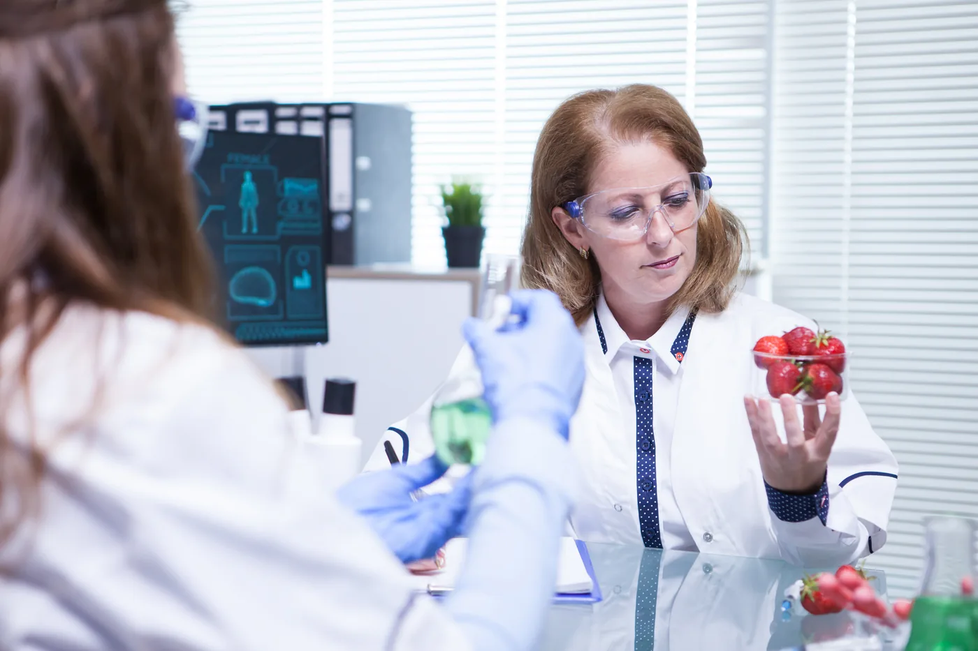 Pracowniczki laboratorium oglądają owoce podczas kontroli jakości